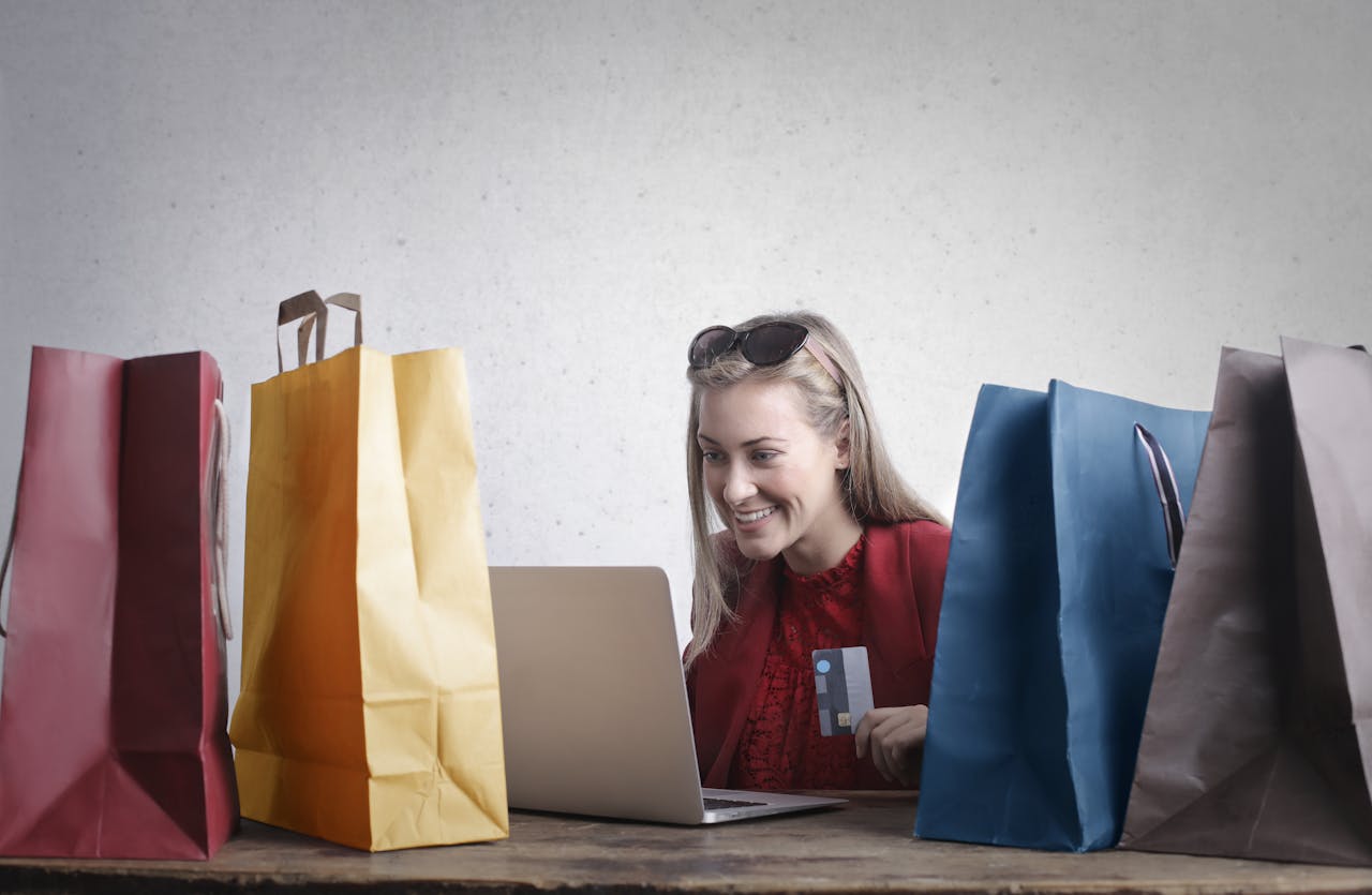 mujer-entre-bolsas-de-compra-con-un-portatil-ejmplo-de-venta-online-en-espana